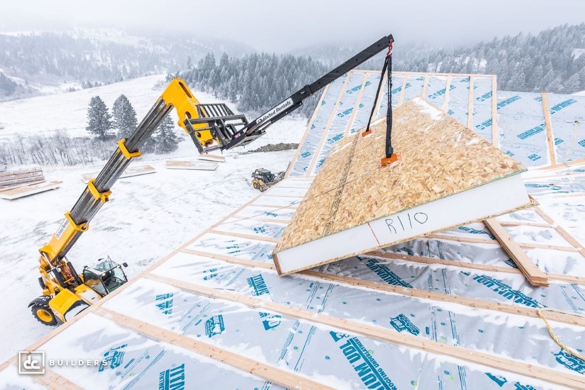sip roof panel being placed by a crane