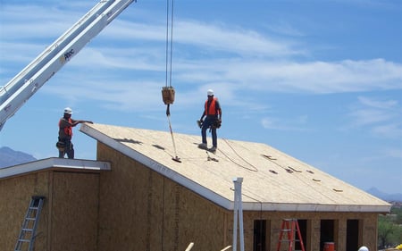 Crew setting SIP roof panels by crane on an Arizona project