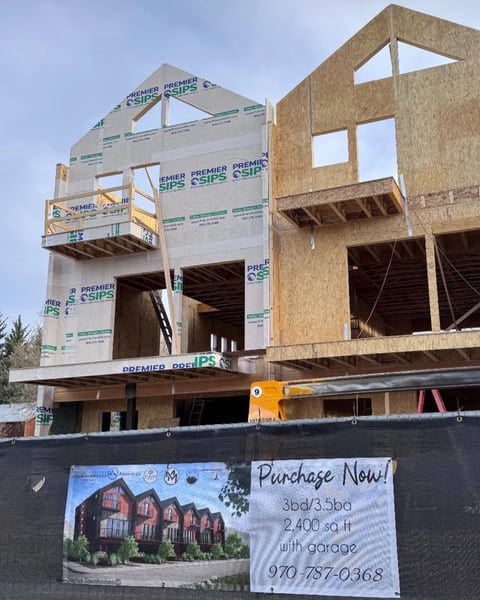 Premier SIPS Townhouses Being Installed. One with building wrap adjacent to a just framed SIP home.